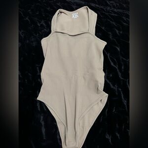 Tan Bodysuit with High-Cut Neckline and Sleek Design